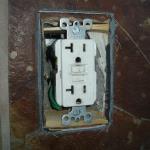This GFCI was installed very poorly. The box to which it is mounted is buried about two inches into the wall. They had to use wood pieces just to give the GFCI support.. The front of the outlet box in the wall should have been flush with the exterior wall surface giving the GFCI support.